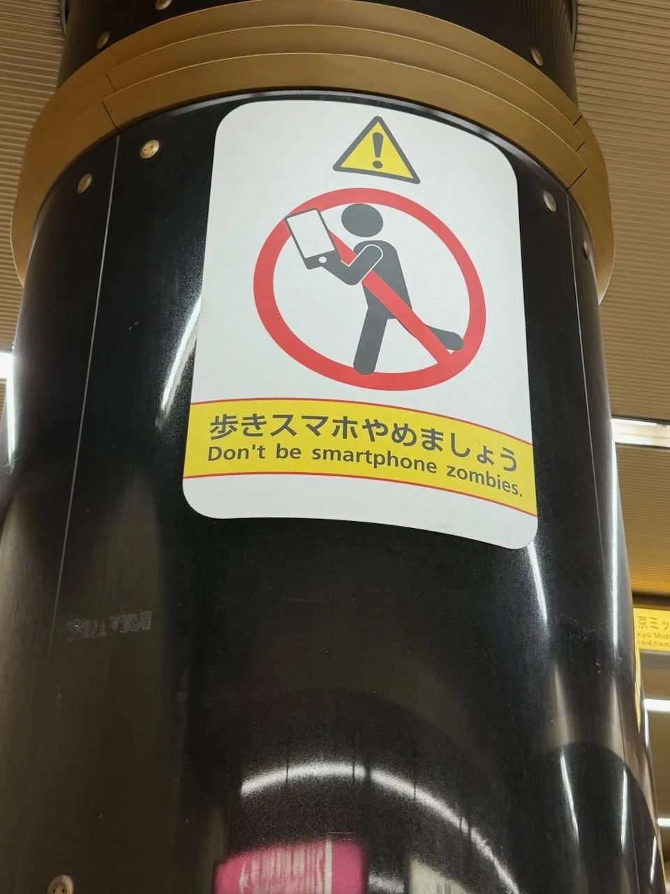 Sign asking people not to walk while using a smartphone, Tokyo, March 2026